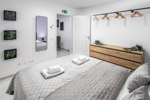 a bedroom with a large bed with two towels on it at BrockHeus Riverside Aparthotel Magdeburg in Magdeburg