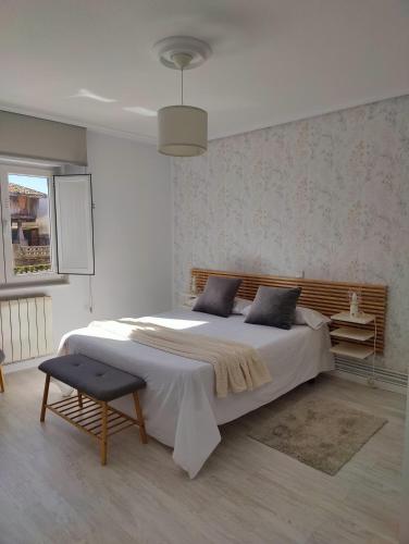 a bedroom with a large bed and a chair at Tu Casina del Norte in Luanco