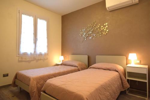 a bedroom with two beds and two windows at Appartamento Dea in Marina di Campo