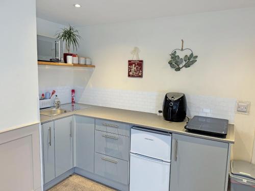 a kitchen with white cabinets and a counter top at Little Nauvoo in Bath