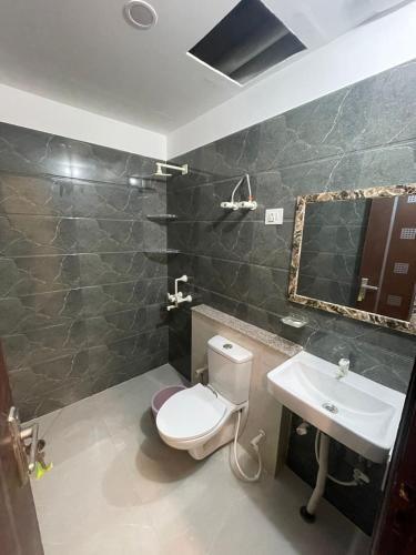 a bathroom with a toilet and a sink at Cozy Inn Hotel in Noida