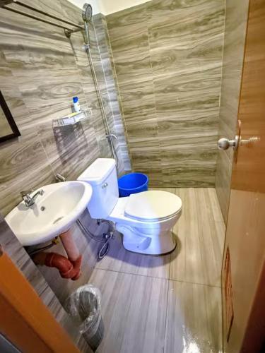 a bathroom with a toilet and a sink at DJL Beach House - Bantayan Island in Patao