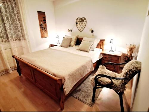 a bedroom with a large bed and a chair at APARTMA ANTON in Bled