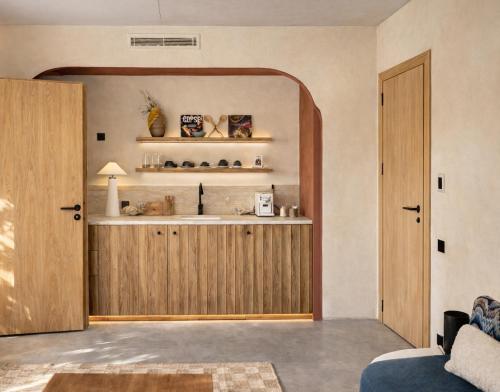 a living room with a wooden door and shelves at Hôtel Mylos - Cargèse, Piscine Intérieure et Extérieure in Cargèse