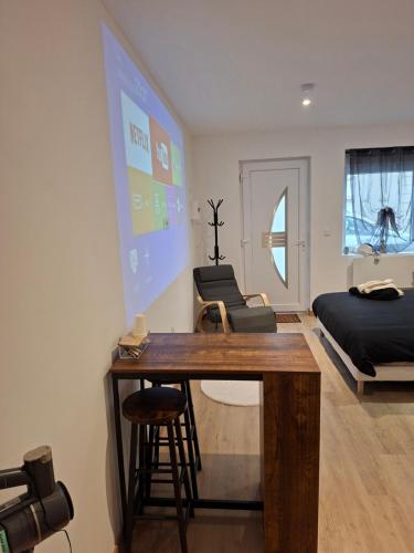 a room with a desk and a bed and a projector screen at Secret Night in Audincourt