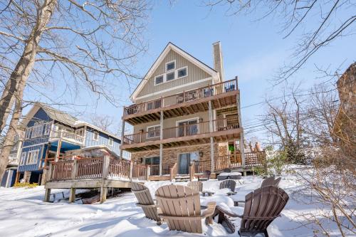 a house with chairs in the snow at Corks Away by Railey Vacations in McHenry