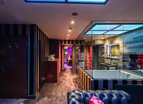 a living room with a couch and a kitchen at Church Suites by The Cranleigh Boutique in Bowness-on-Windermere