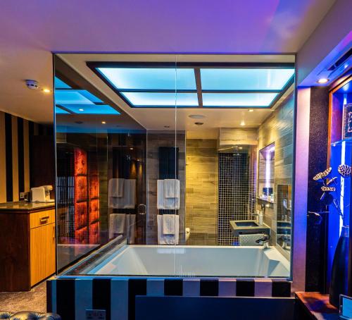 a large bathroom with a tub and a sink at Church Suites by The Cranleigh Boutique in Bowness-on-Windermere