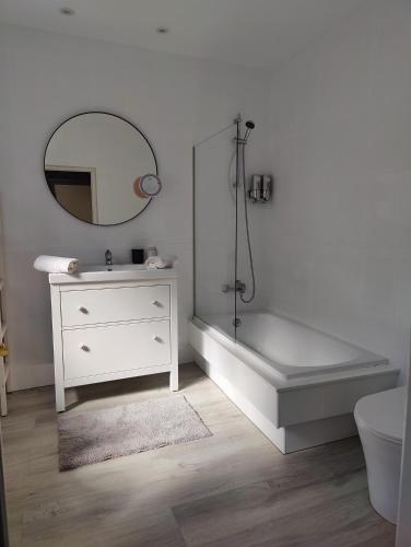 a bathroom with a tub and a sink and a mirror at Tu Casina del Norte in Luanco