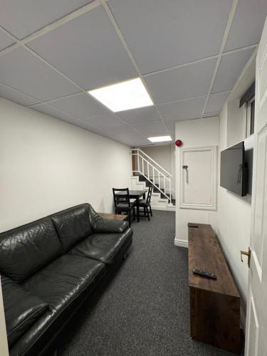a living room with a leather couch and a table at Hotels 24-7 - The Old Knoll Guesthouse in Newport