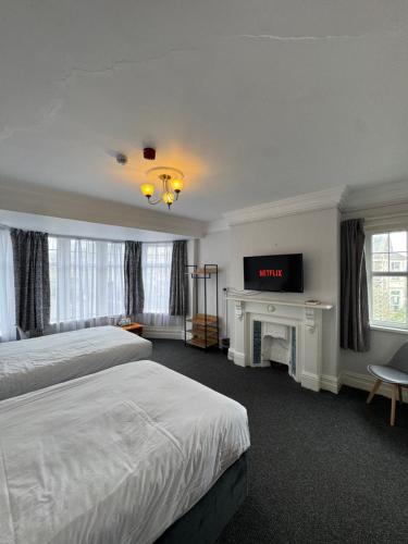 a hotel room with two beds and a fireplace at Hotels 24-7 - The Old Knoll Guesthouse in Newport