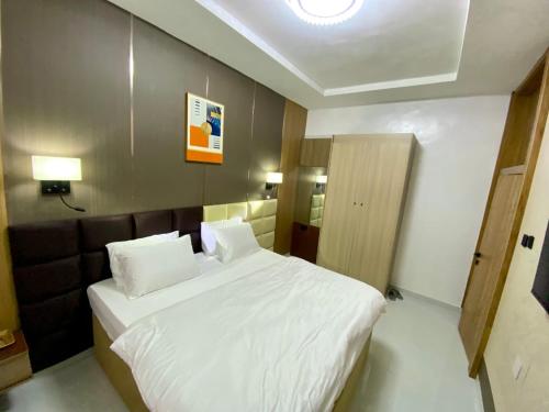 a bedroom with a large white bed in a room at Ghomes in Lagos