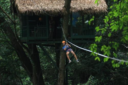 a man on a zip line in a tree house at Namkat Yorla Pa Resort in Ban Kat