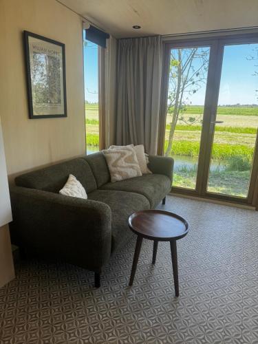 a living room with a couch and a table at Tinyhouse Polderpanorama in Haastrecht