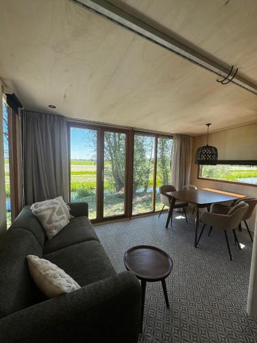 a living room with a couch and a table at Tinyhouse Polderpanorama in Haastrecht