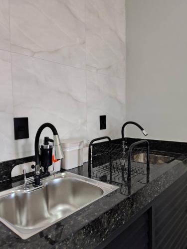 a kitchen sink with two faucets on a counter at Studios Leme 11 - conforto para casal - com varanda in Espirito Santo Do Pinhal