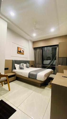 a bedroom with a bed and a desk in a room at Hotel Leaf inn in Ahmedabad