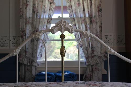 a bed with a canopy in front of a window at Coonawarra's Pyrus Cottage in Coonawarra