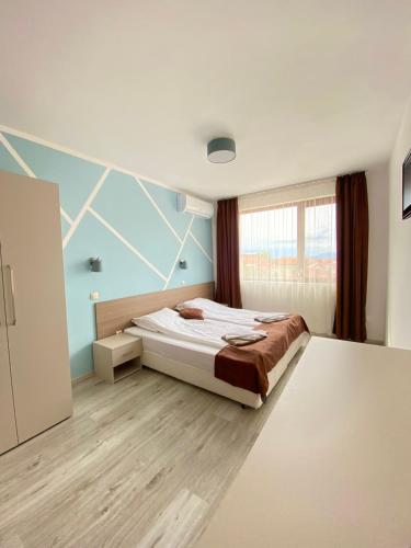a bedroom with a bed and a blue wall at Sapareva Apartments in Sapareva Banya