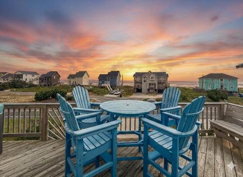 a table and chairs on a deck with a view of the beach at On The Beach - Kitty Hawk, MP 1, Less than 50 Yards to Beach, Ocean View, Pool, Hot Tub, Pets OK in Kitty Hawk