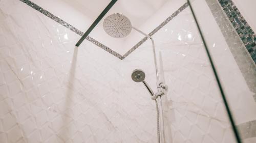 a shower with a shower head in a bathroom at Winy Home Lovina in Lovina