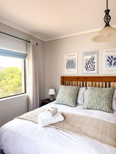 a bedroom with a large white bed with a window at Fluisterbaai in Britannia Bay