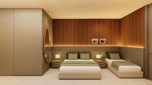 a bedroom with two beds and a mirror at Verde da Mata Hotel in Juazeiro do Norte
