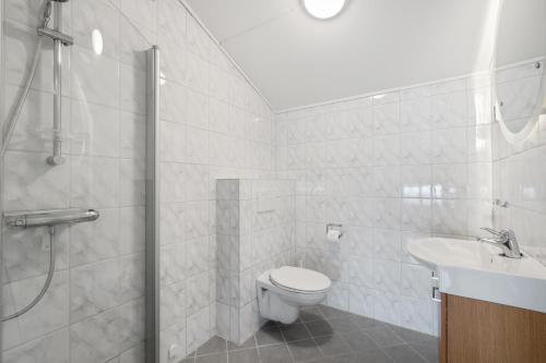 a white bathroom with a toilet and a sink at Stølstunet Leilighet 617 in Beitostøl