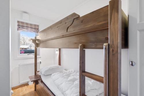 a bunk bed with white pillows on it at Stølstunet Leilighet 617 in Beitostøl