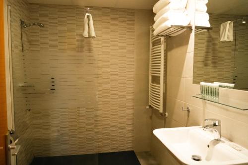 a bathroom with a sink and a shower at Apartamentos SNÖ Edelweiss in Cerler