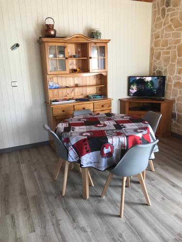 Petit chalet في ميرفيل-فرانسفيل بلاج: طاولة وكراسي في غرفة بها تلفزيون