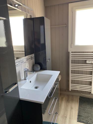 Petit chalet في ميرفيل-فرانسفيل بلاج: حمام به حوض أبيض وثلاجة سوداء