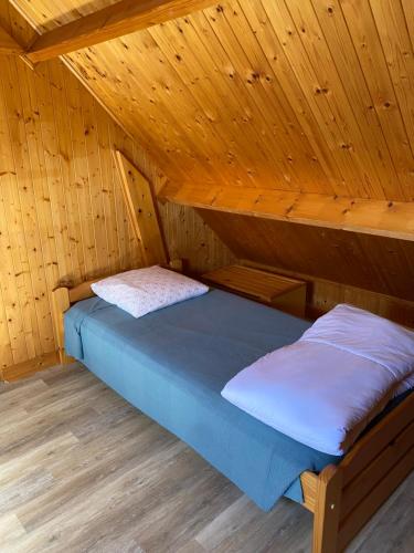 Petit chalet في ميرفيل-فرانسفيل بلاج: غرفة نوم مع سرير في كابينة خشبية
