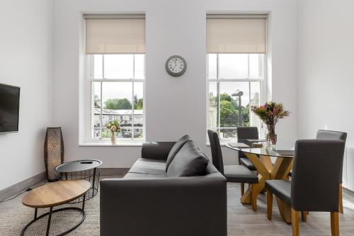 a living room with a couch and a table at The Lion Gate Mews in Kingston upon Thames