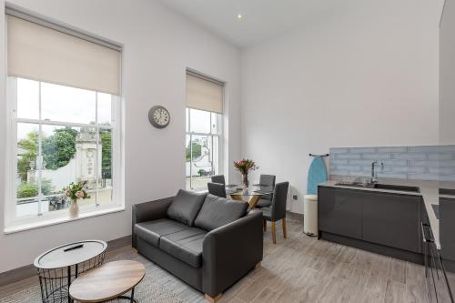 a living room with a couch and a table at The Lion Gate Mews in Kingston upon Thames