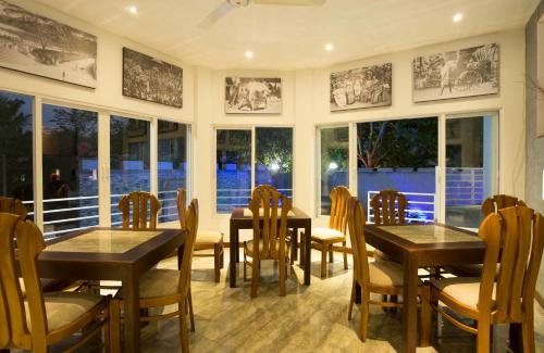 a dining room with tables and chairs and windows at Winter Villa in Kandy