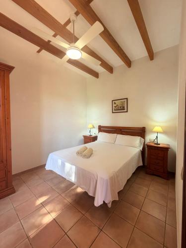 a bedroom with a white bed and two night stands at Son Rapinya Porto Cristo in Porto Cristo