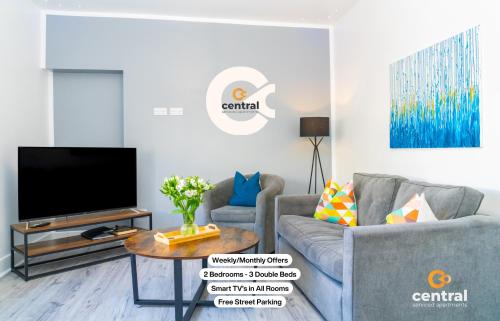 a living room with a tv and a couch and a table at Sandeman by CENTRAL SERVICED APARTMENTS - 2 Bedroom - FREE Street Parking - Fast WiFi - Smart TVs in All Rooms - Ground Level - Family Neighbourhood - 3 x Double Beds - Heating 24-7 - Trade Stays - Weekly & Monthly Offers in Dundee
