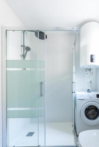 a bathroom with a shower and a washing machine at Rodas Apartment in Torrevieja