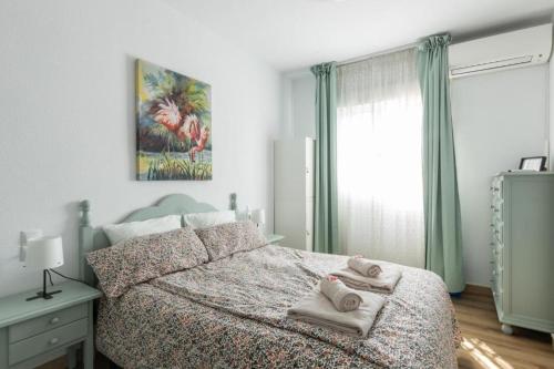 a bedroom with a bed with towels on it at Rodas Apartment in Torrevieja