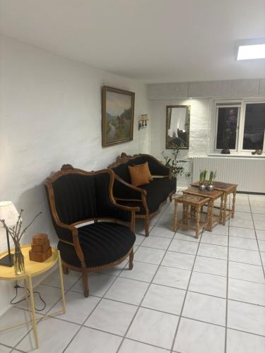a living room with couches and tables at Herregårdslejlighed in Vrå