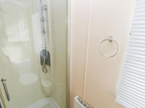 a bathroom with a shower and a glass door at Under Cliff Caravan in Ferryside