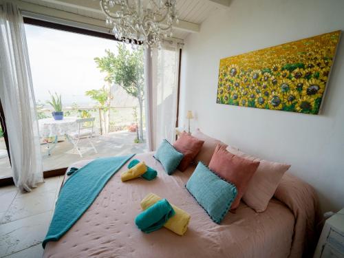 a bedroom with a bed with pillows and a painting at El Laurel in Frontera