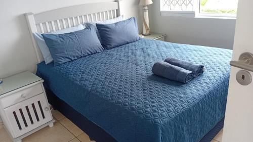 a bedroom with a blue bed with blue sheets and pillows at Mangrove Beach Estate, Dadda's Place, 321 Bokmakierie WY in Melville