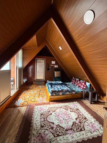 a attic room with two beds and a rug at Holidays homestay in Mirik