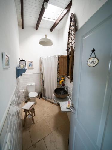 a bathroom with a sink and a toilet and a door at El Laurel in Frontera