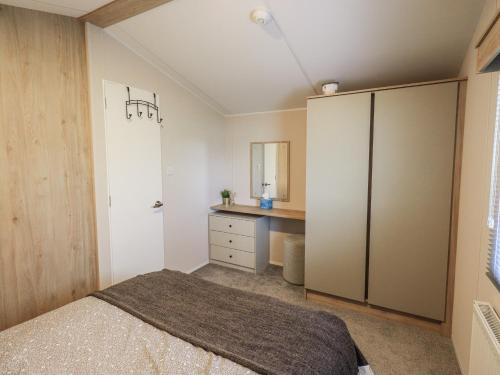 a bedroom with a bed and a desk at Hadrian's Rest Glendale Holiday Park in Wigton