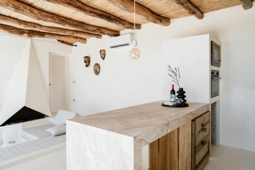a kitchen with white walls and a wooden island at Casa Arim in Orosei