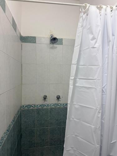 a shower with a white shower curtain in a bathroom at Colorín RB in La Paz