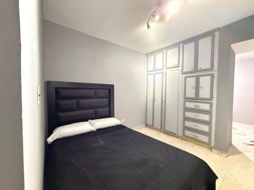 a bedroom with a black bed and a dresser at Colorín RB in La Paz
